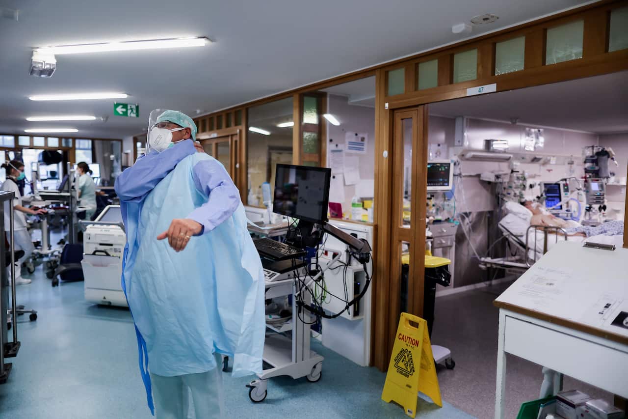 A medical worker puts on his personal protective equipment before work at the intensive care unit at The University Hospital Centre, in Liege, on 22 October.
