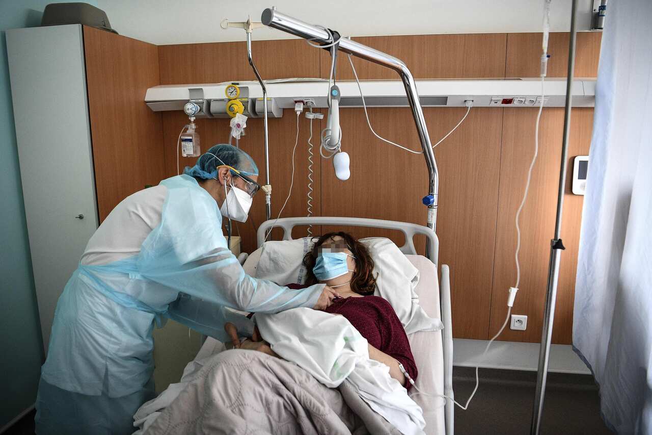 A doctor tends to a patient infected with COVID -19 in the infectious diseases unit of the Gonesse hospital north of Paris, 22 October, 2020.
