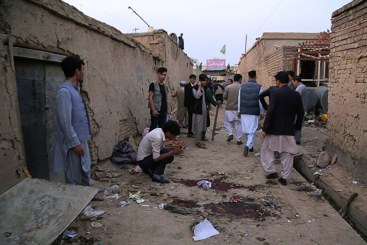 Residents gather at a site following a suicide bomber blew himself up in an education centre, in Kabul on 24 October, 2020. 