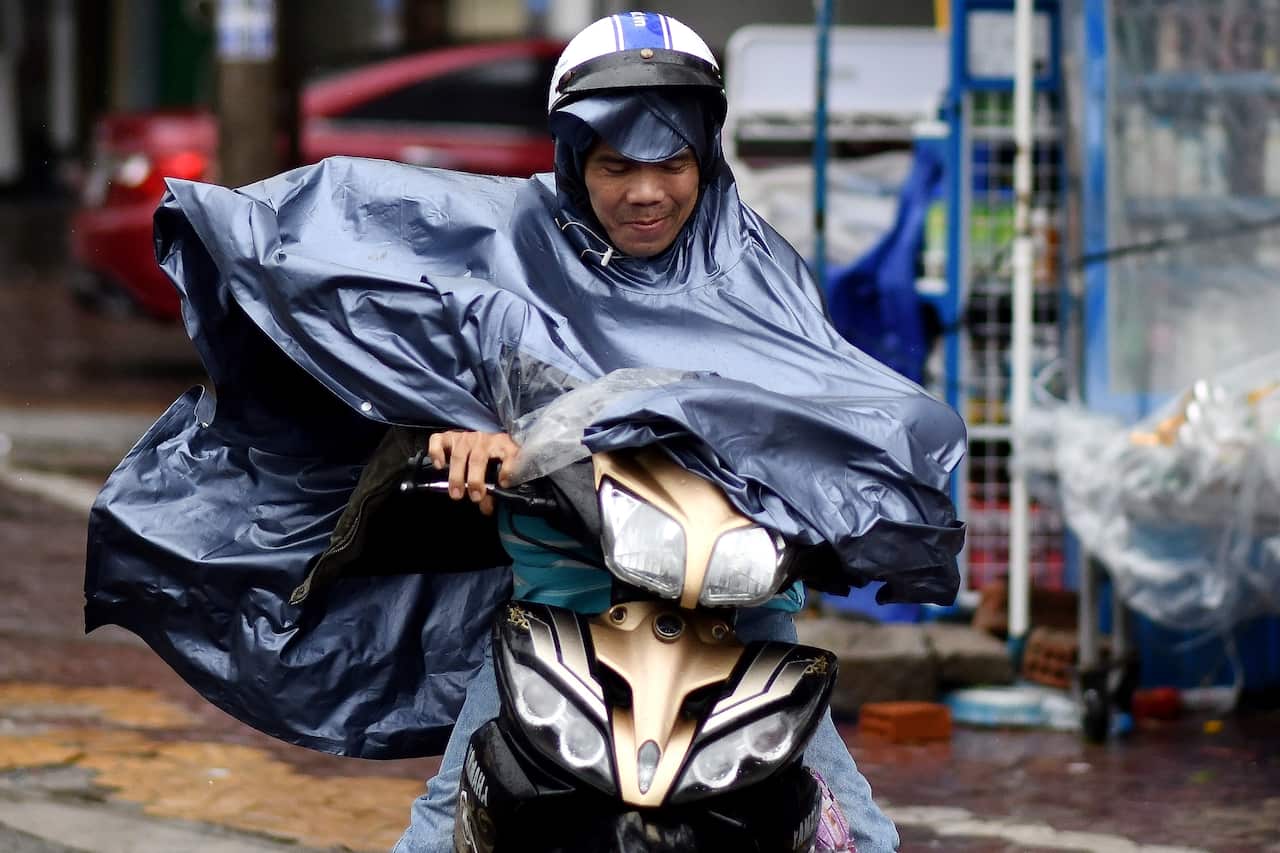 A motorist braves strong winds while riding along a street in central Vietnam's Quang Ngai province on October 28, 2020, as Typhoon Molave makes landfall.