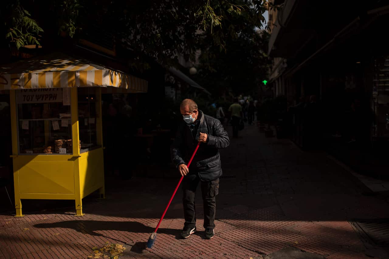 A man, wearing a protective face mask, cleans a street in Athens' main commercial district in Greece on 30 October.