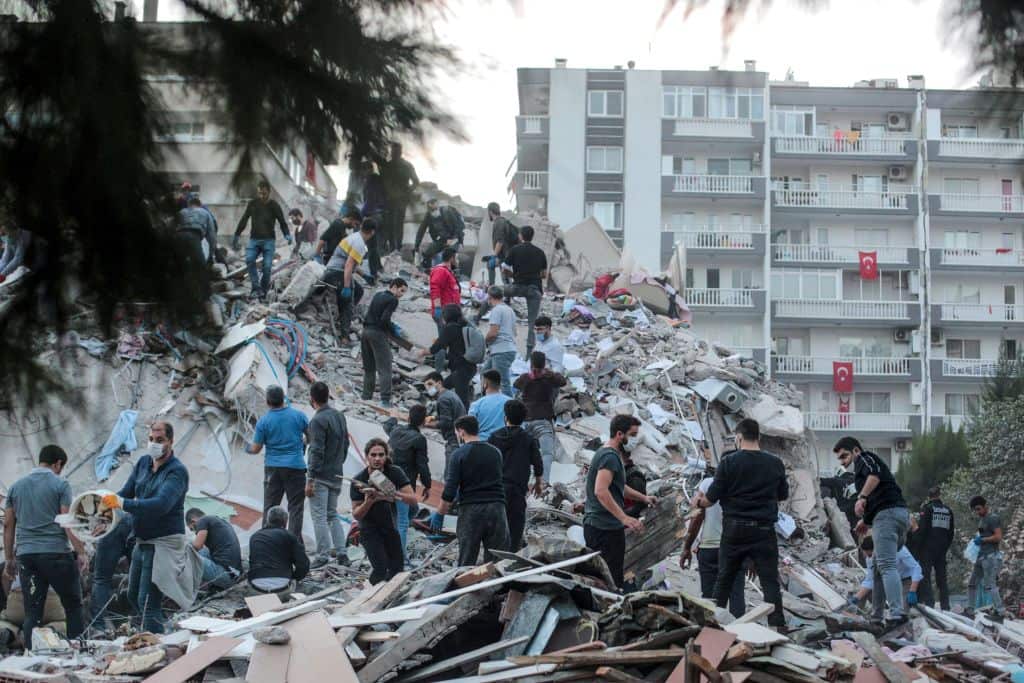 Volunteers clear rubbles as they search for survivors in a collapsed building after a strong earthquake struck the country's western coast and parts of Greece.