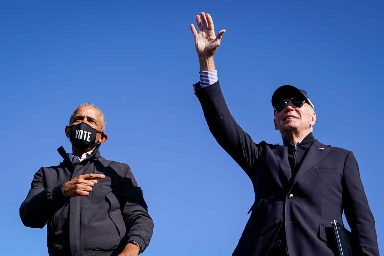 Former US President Barack Obama and Democratic presidential nominee Joe Biden at a drive-in campaign rally on 31 October in Flint, Michigan.
