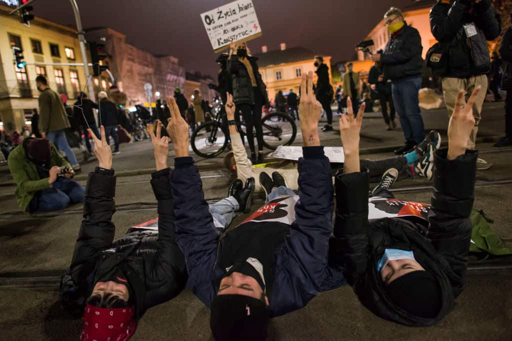 Protesters laying down on the tram tracks while making
