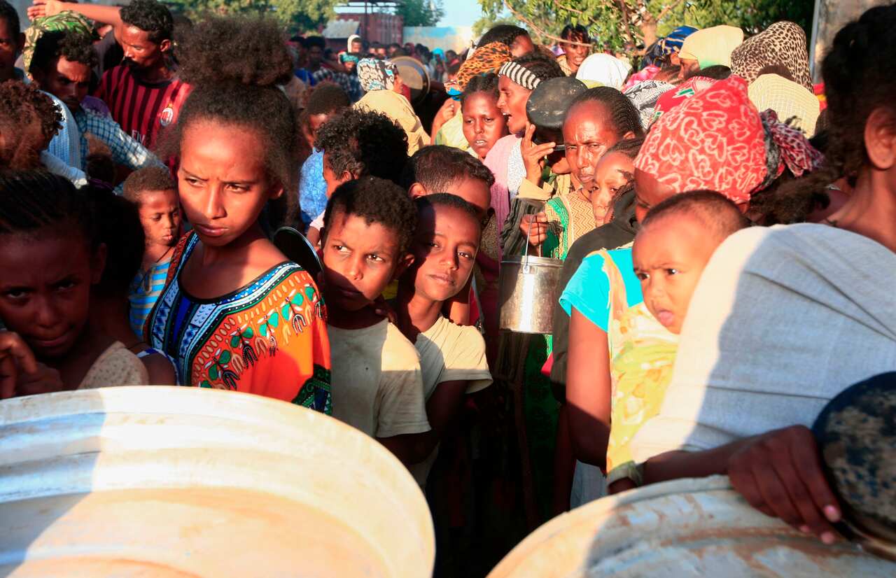 Ethiopian refugees who fled intense fighting in Tigray wait for their ration of food in the border reception centre of Kassala in Sudan, on 14 November, 2020.
