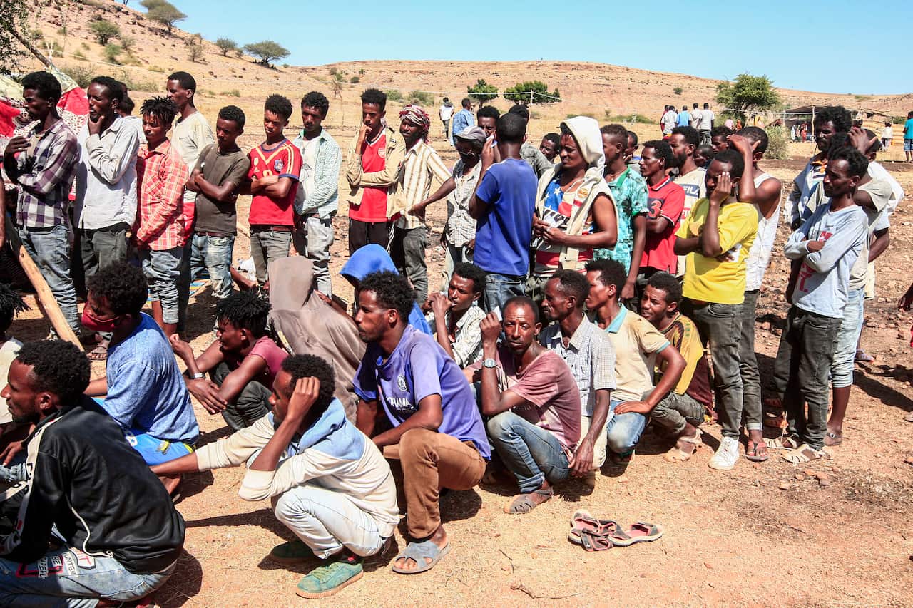 Ethiopian refugees fleeing fighting in Tigray province queue to receive supplies at the Um Rakuba camp in Sudan's eastern Gedaref province, on 16 November.