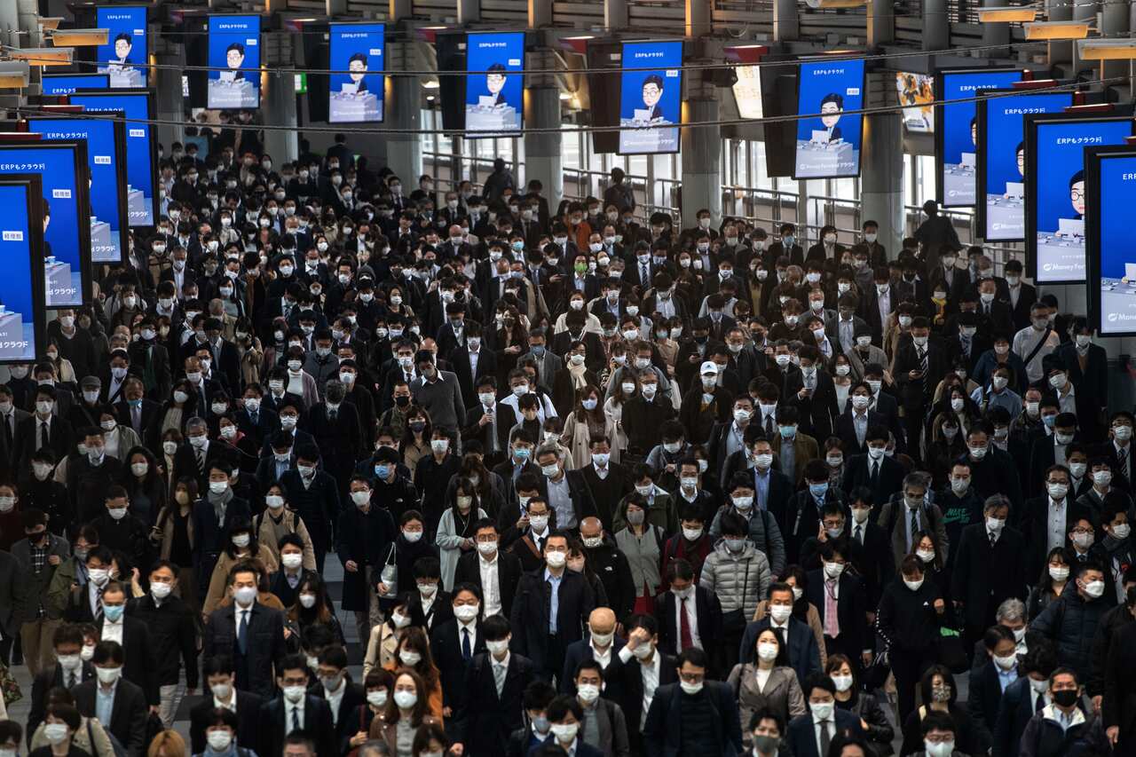 Commuters wearing face masks walk at Shinagawa Station in Tokyo on 19 November, 2020.