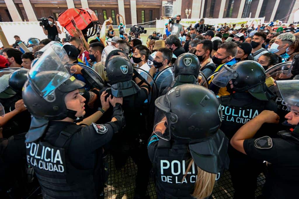 Fans confront riot police as they try to reach the Casa Rosada presidential palace to pay tribute to late Argentine football legend Diego Maradona.