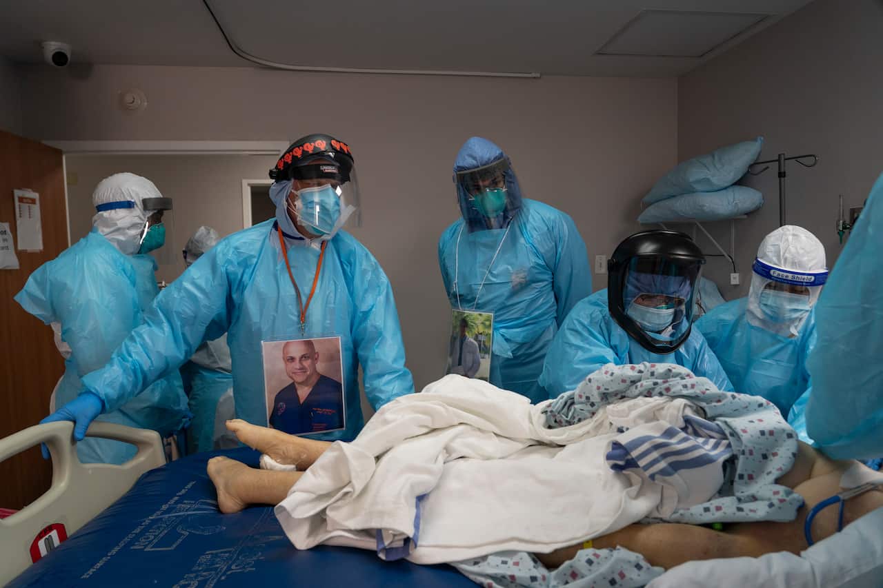 Dr Joseph Varon (2nd L) supervises the handling of a patient after death in the COVID-19 intensive care unit at the United Memorial Medical Center on in Houston