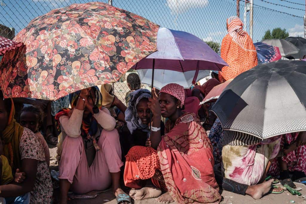Ethiopian refugees who fled the Ethiopia's Tigray conflict wait for charity contributions at the Border Reception Centre in Hamdayit, eastern Sudan.