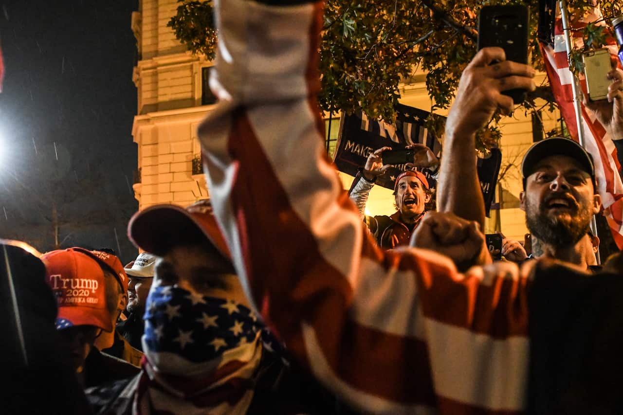Donald Trump supporters react to a speech by Alex Jones during a protest in Washington, DC, on 12 December.