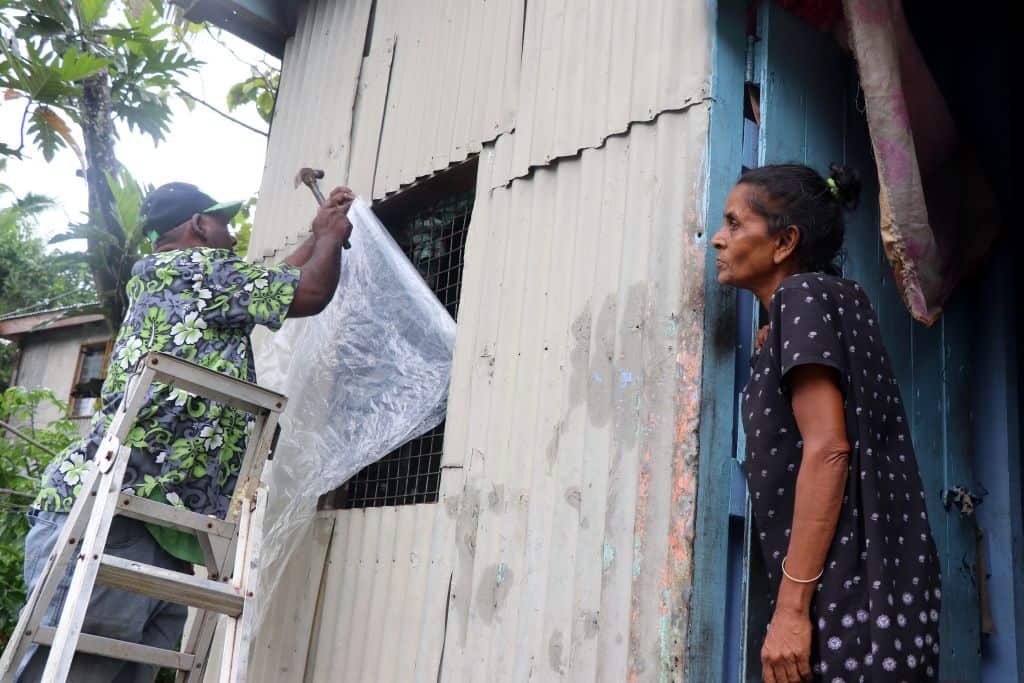 Residents try to safeguard their house by placing plastic sheets on the windows ahead of the arrival of super Cyclone Yasa in Fiji.