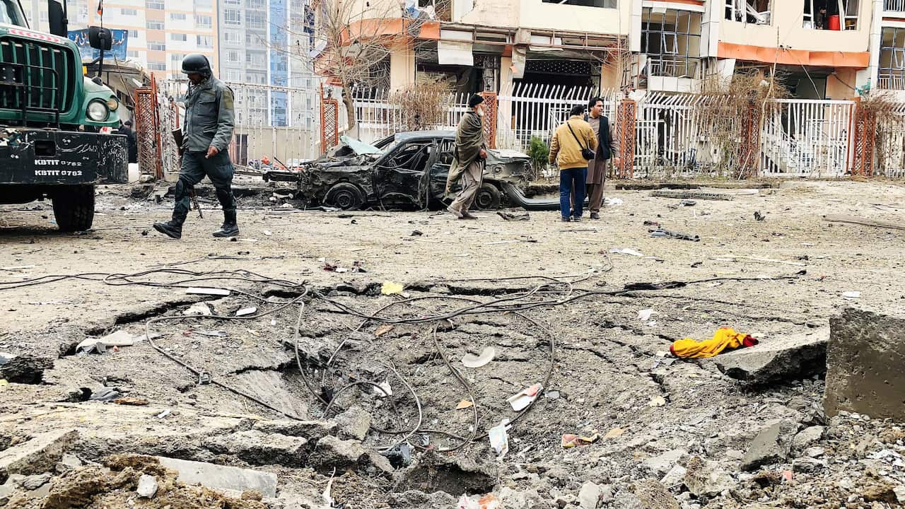People inspect the site after a bomb-laden car exploded in Afghanistan's capital Kabul.