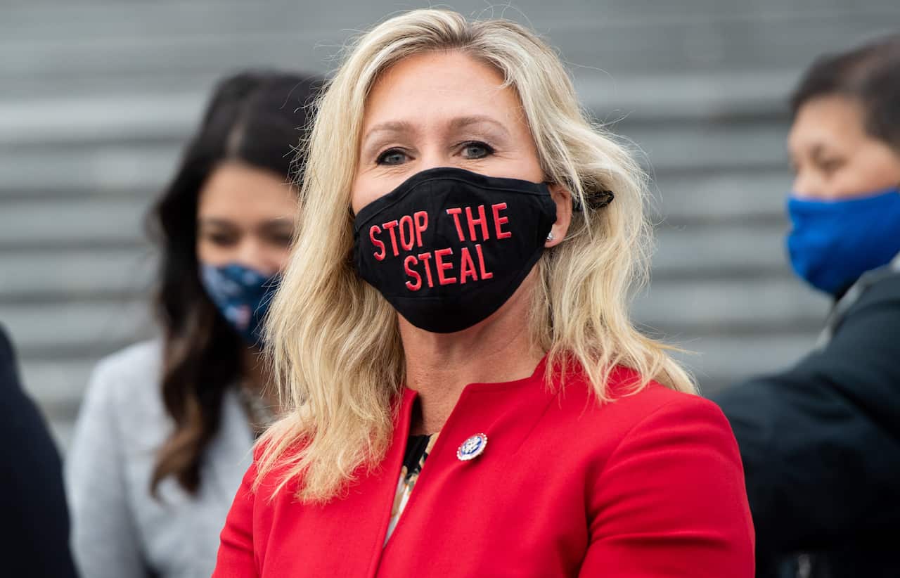 Marjorie Taylor Greene wears a "Stop the Steal" mask while speaking with fellow first-term Republican members of Congress at the US Capitol on 4 January.
