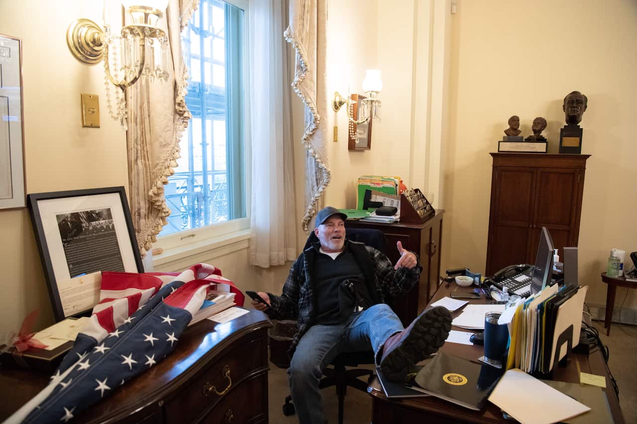 Richard Barnett sits inside the office of US Speaker of the House Nancy Pelosi during a riot at the US Capitol in Washington, DC, on 6 January.