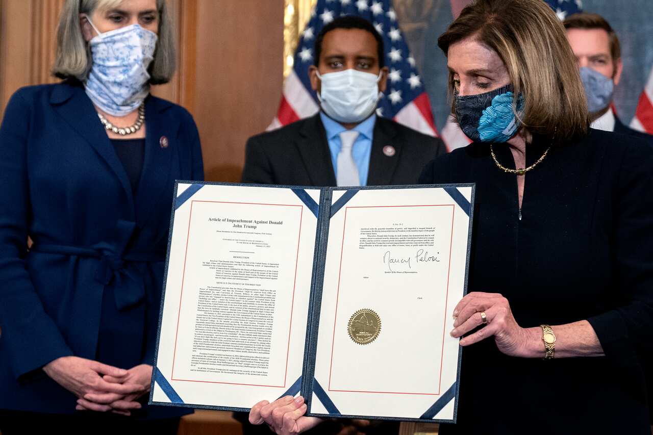 Nancy Pelosi displays a signed article of impeachment against then-President Donald Trump at the US Capitol on January 13, 2021.