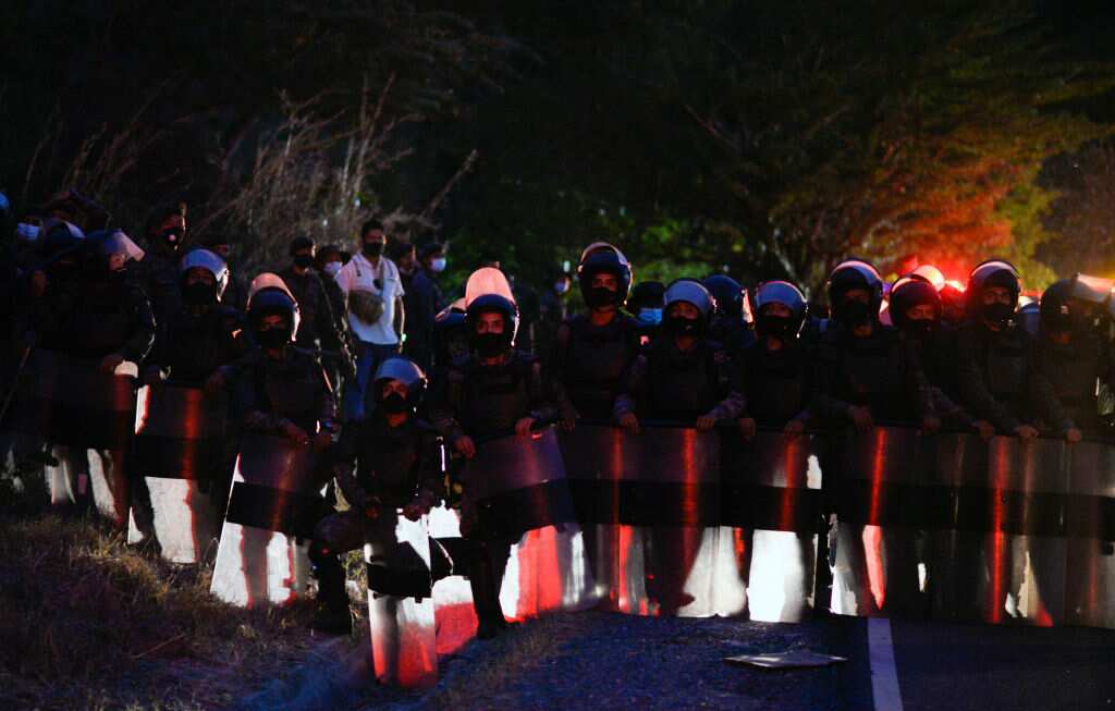 Guatemalan Army members stand guard nearby Honduran migrants on their way to the United States, at Vado Hondo in Guatemala, on 16 January, 2021. 