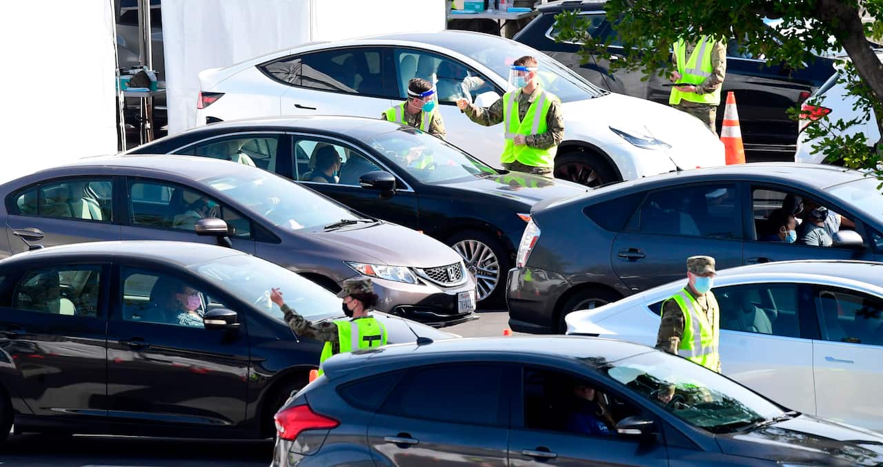 Motorists arrive for their COVID-19 vaccinations administered by members of the National Guard at a new mass vaccination site in Los Angeles on 16 February.