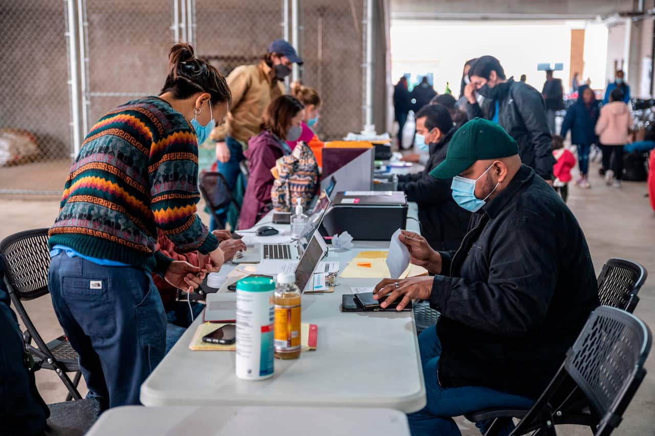 Former residents of a migrant camp in Matamoros, Mexico, receive legal and clerical help in a parking garage in Brownsville, Texas.