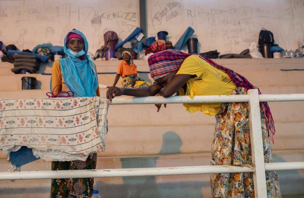 Internally displaced people from Palma gather in a sports centre to receive humanitarian aid in Pemba, Mozambique, on 2 April 2021.