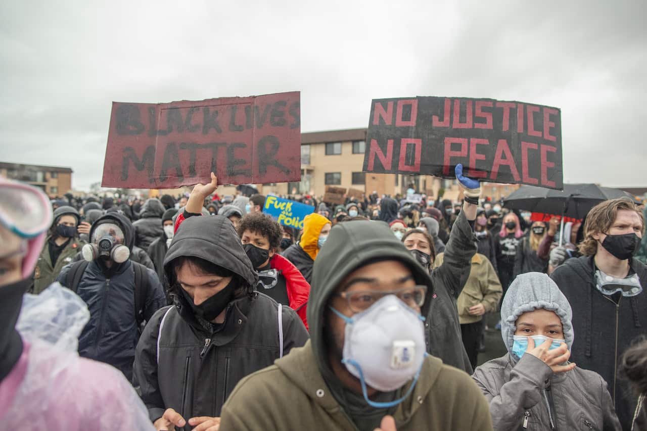 Protesters gather outside of the Brooklyn Center police station in Minnesota as they protest the police killing of Daunte Wright on 13 April.