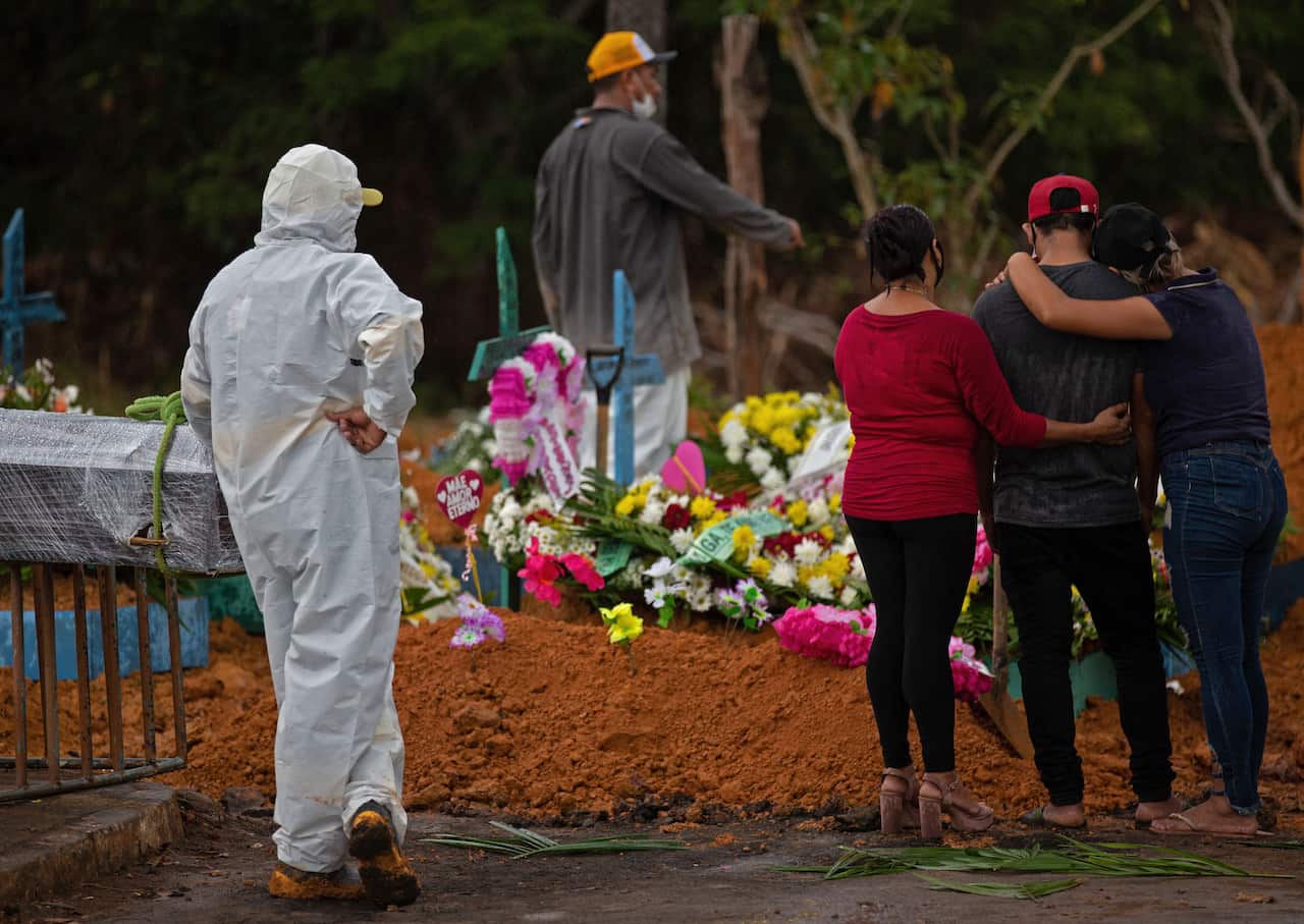 Relatives attend a COVID-19 victim's burial at the Nossa Senhora Aparecida cemetery in Manaus, Amazon state, Brazil, on 15 April, 2021.