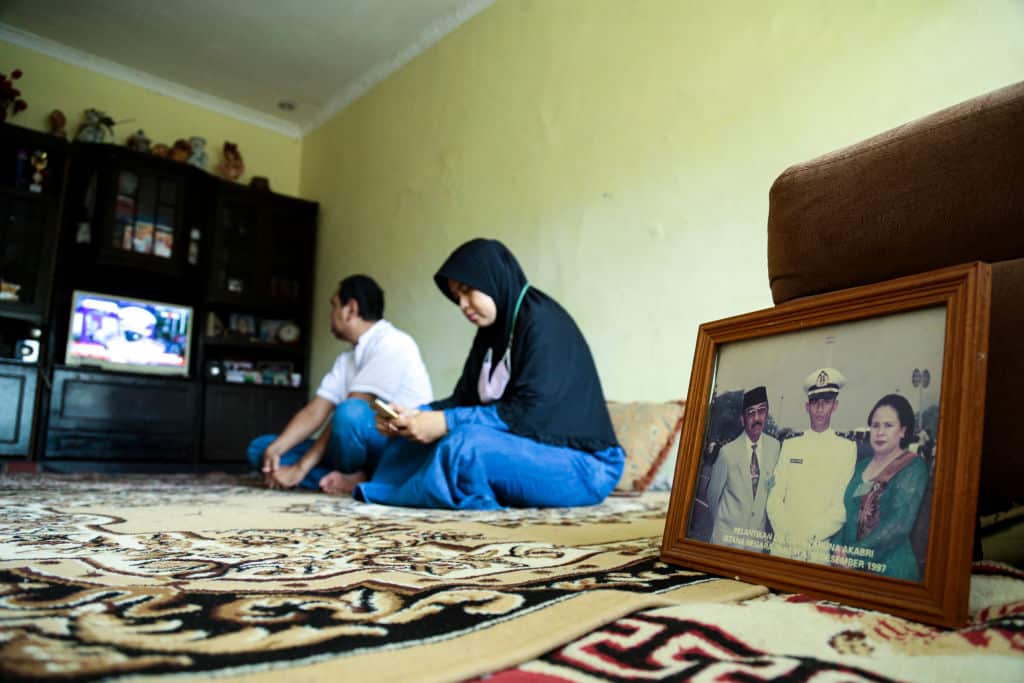Family members show a photograph of Marine Colonel Harry Setiawan, commander of the Navy's KRI Nanggala (402) submarine that went missing off the coast of Bali.