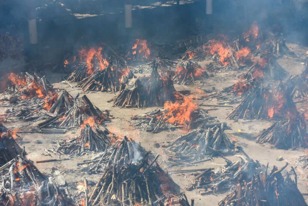 Multiple funeral pyres of people who died of COVID-19 burning simultaneously at Gazipur crematorium in New Delhi, India.