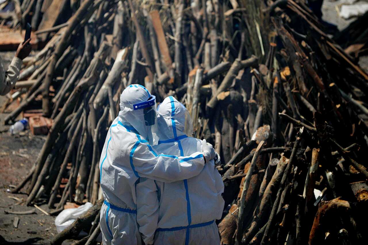 Relatives mourning next to pyres of Covid-19 deceased people at a crematorium in New Delhi.