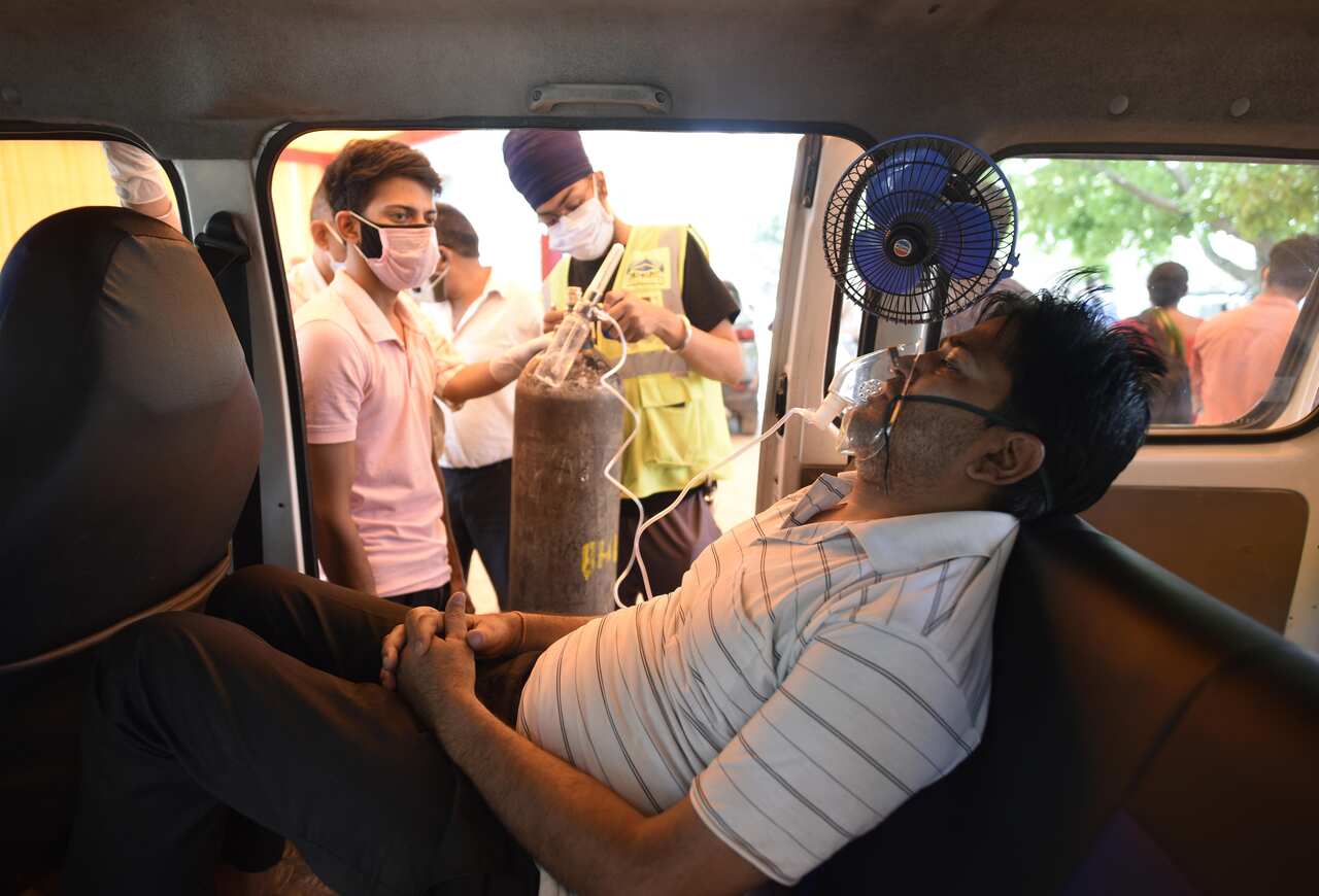 A COVID-19 patient receiving oxygen support in a vehicle on 27 April, 202, in Gurugram, India. 