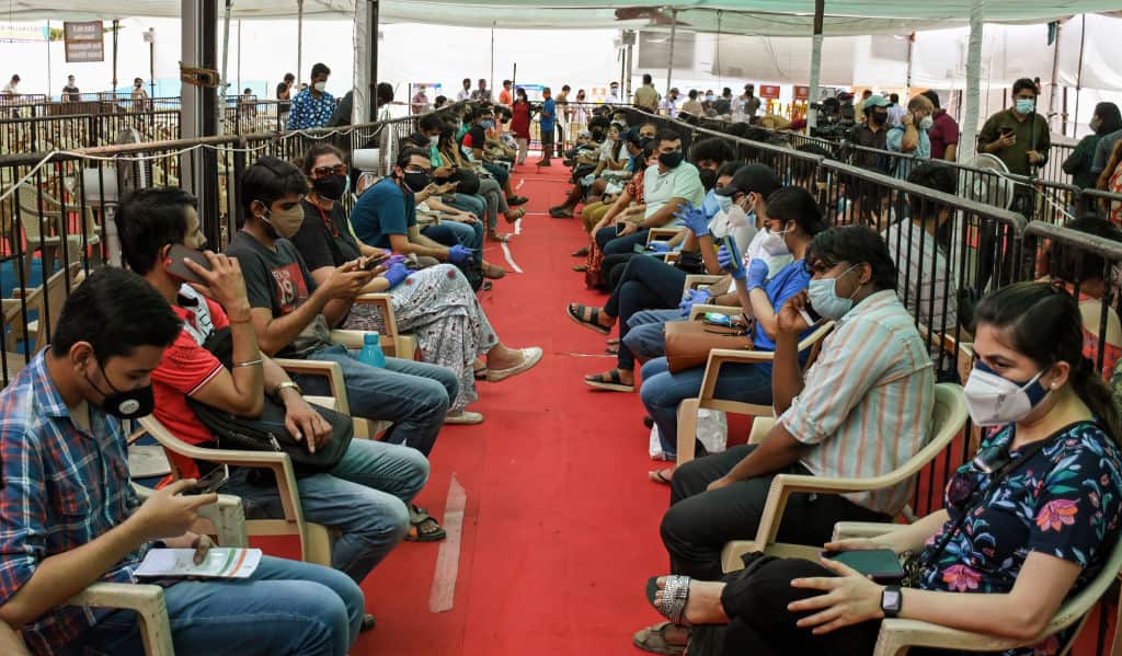 People wait in queues inside the Bandra Kurla Complex vaccination centre in Mumbai.