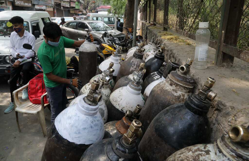 A worker lines up refilled oxygen cylinders in New Delhi, India.