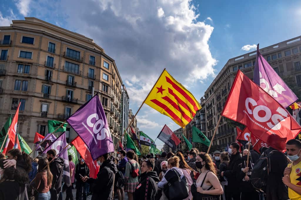 Protesters holding various flags of unions and political parties during demonstration in Catalonia, Spain.