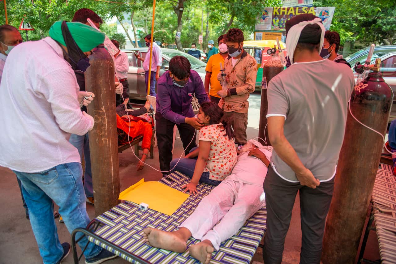 A health worker attends to a young COVID-19 patient who is having trouble breathing outside Gurudwara Sri Guru Singh Sabha in Ghaziabad, Uttar Pradesh on 3 May.