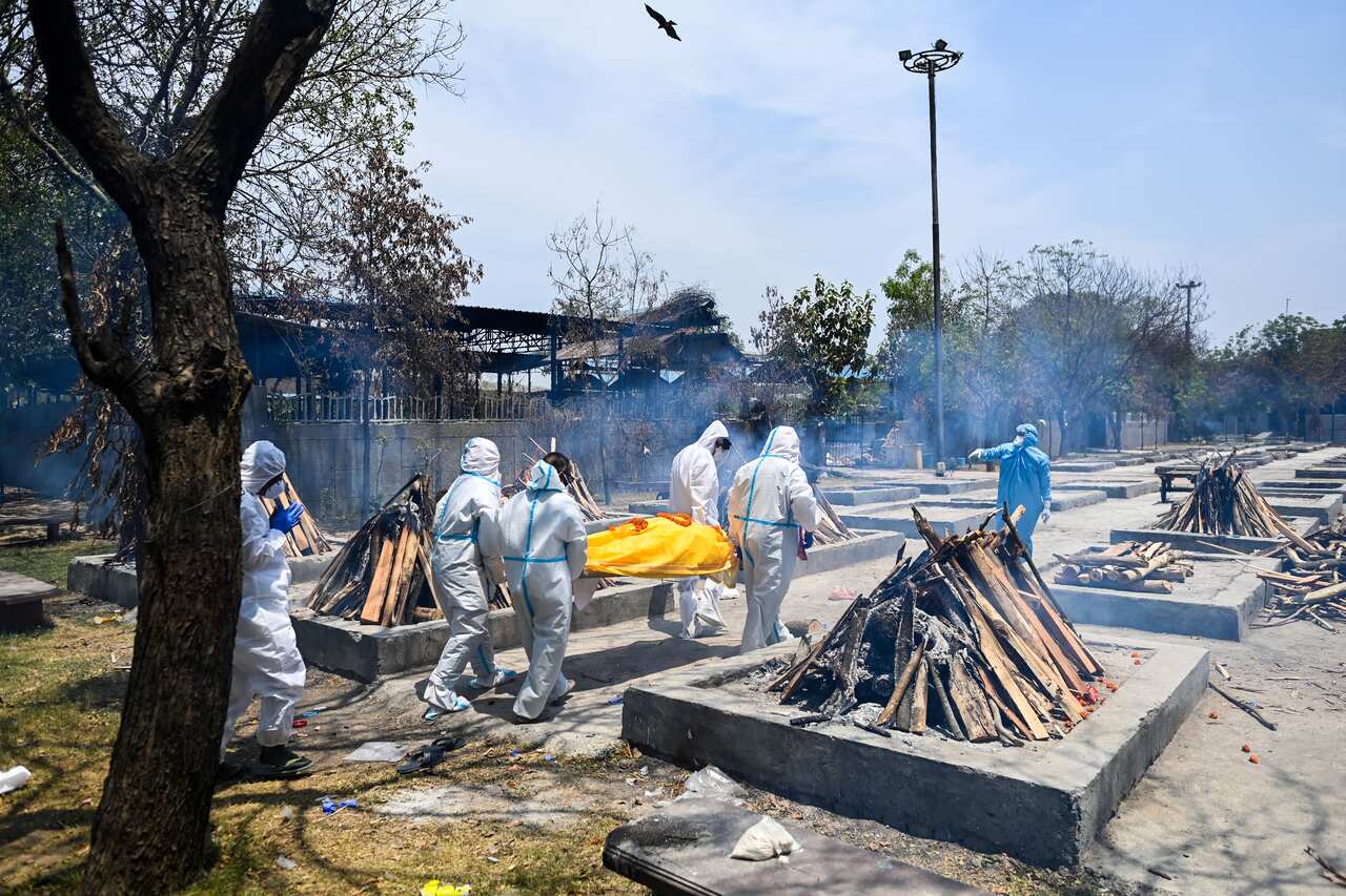 Relatives bring the body of a COVID-19 victim to a cremation ground in New Delhi on 11 May, 2021. 