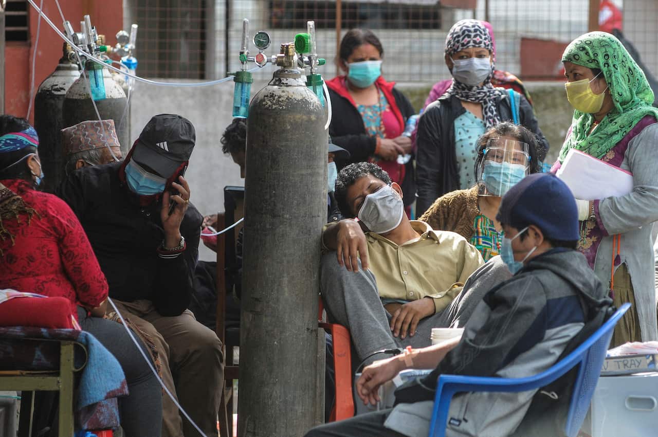 COVID-19 patients breath with the help of oxygen as they wait to be admitted at the Sukraraj Tropical and Infectious Disease Hospital in Kathmandu on 13 May.