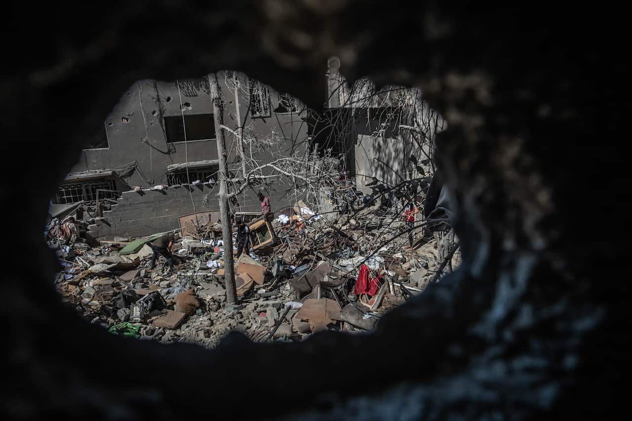 Palestinians inspect a family house at al-Shati Refugee Camp, west of Gaza City, after it was struck in an Israeli air strike on 15 May, 2021.