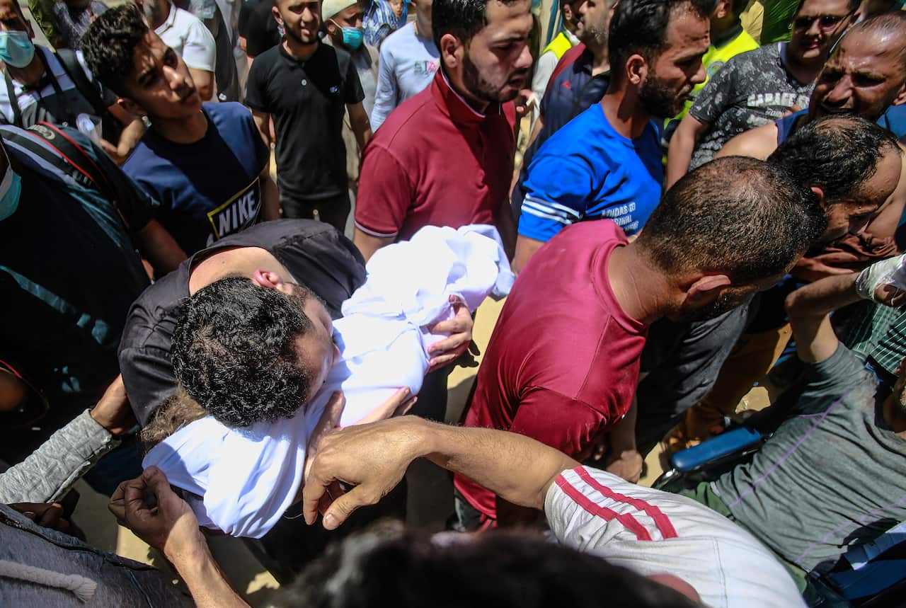 Palestinians carry the body of a Palestinian child who was killed in an Israeli airstrike.