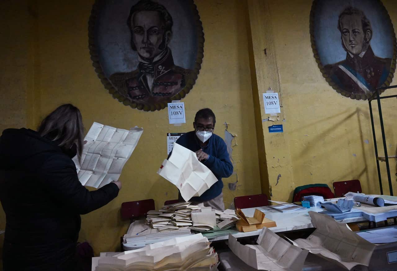 Members of the electoral table count votes at a polling station during elections to choose mayors, councillors and a commission to rewrite the constitution.