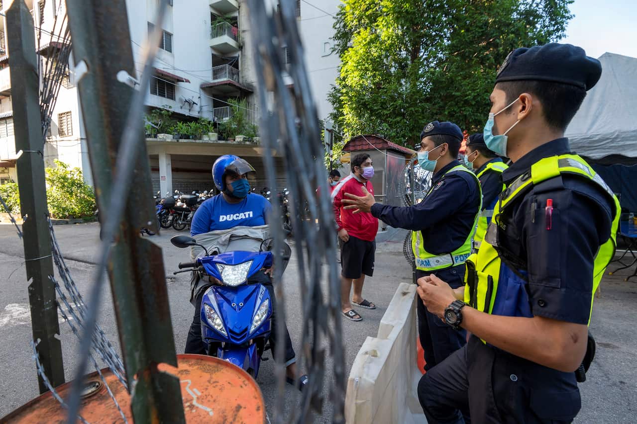 Police talk with residents in an area under an enhanced movement control order due to the surge of Covid-19 cases in Cheras on the outskirts of Kuala Lumpur, Malaysia (28 May 2021).