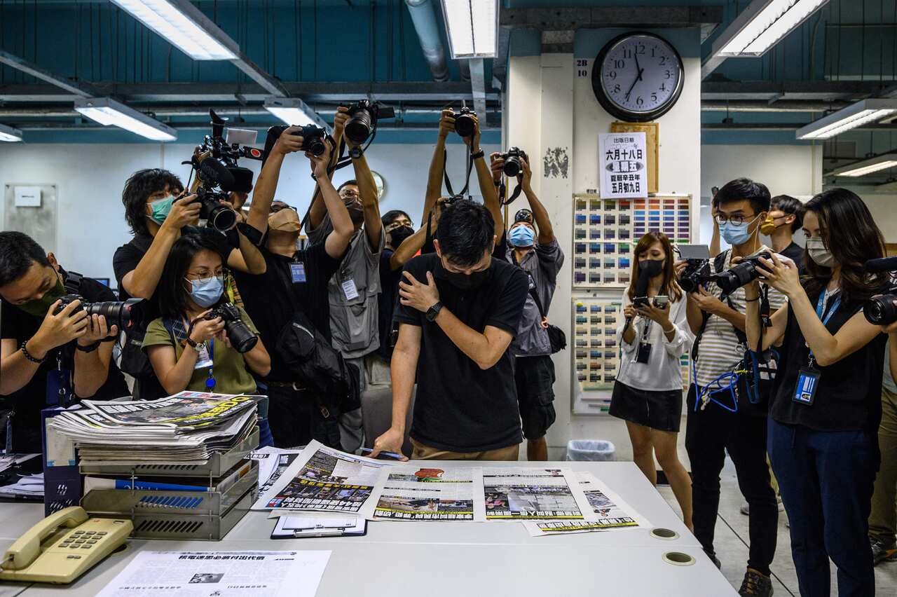 Members of the press take photos as executive editor in chief Lam Man-Chung proofreads the next day's Apple Daily before it goes to print late on 17 June.