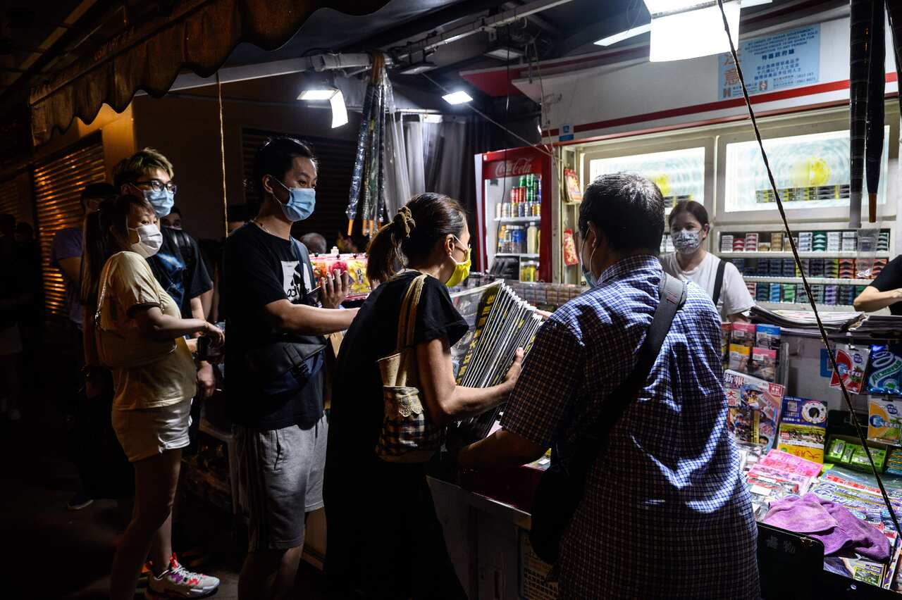 A customer buys multiple copies of the Apple Daily newspaper at a newsstand in Hong Kong early on 18 June, 2021.