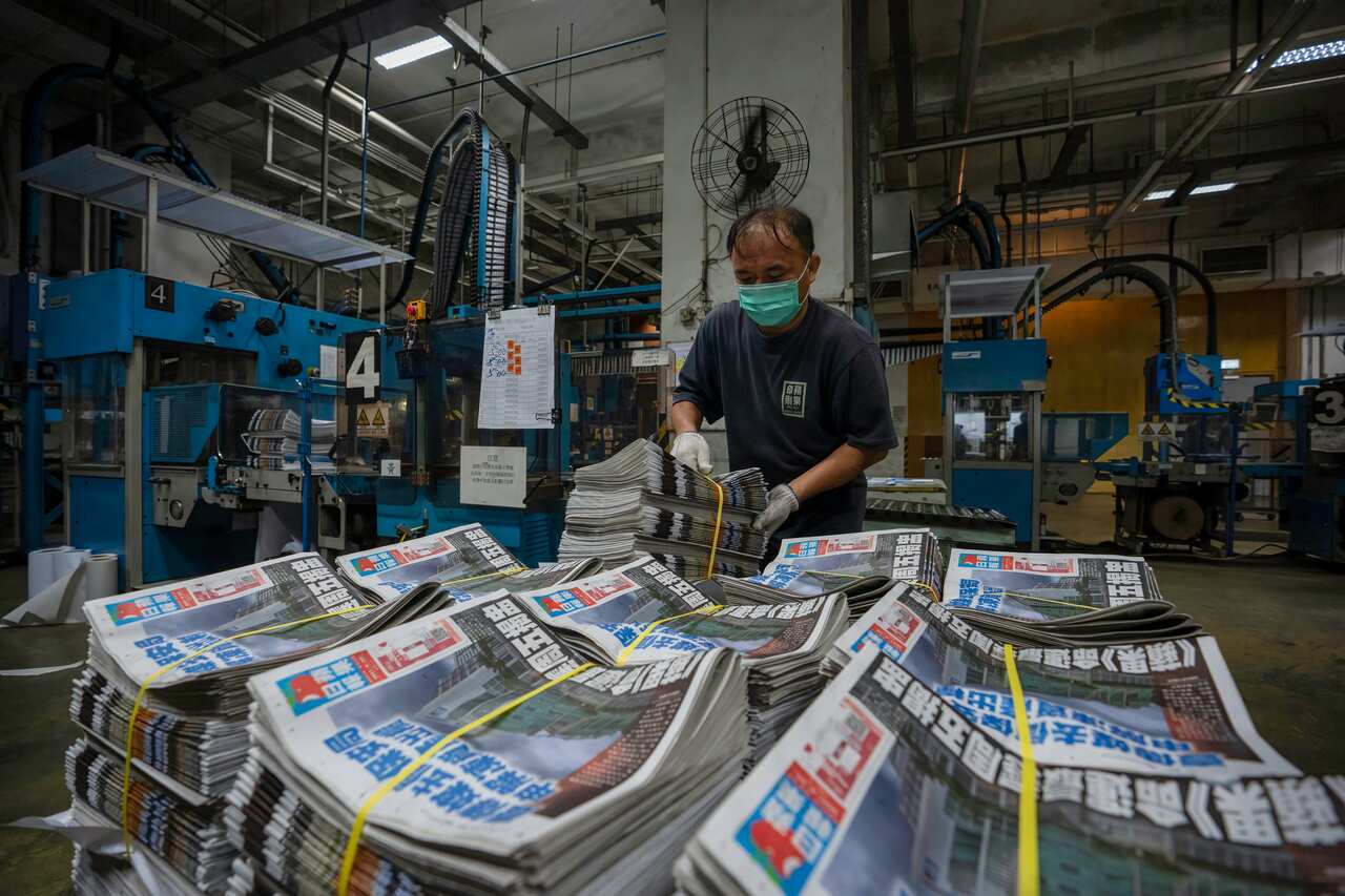 An employee stacks freshly printed newspapers onto a pallet in the Apple Daily printing facility in Hong Kong.