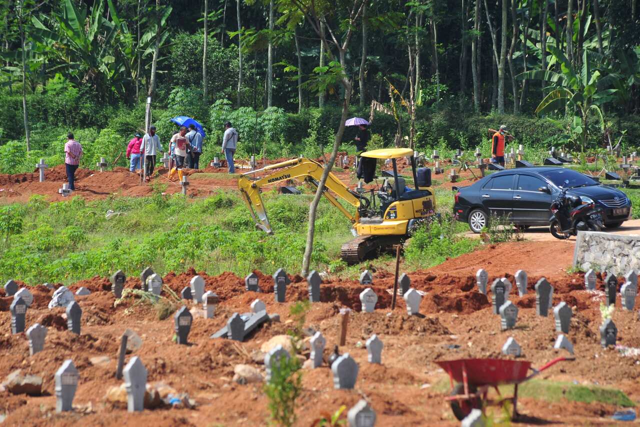 Gravediggers prepare to bury more bodies at a cemetery designated for victims of the COVID-19 coronavirus in Semarang, Indonesia, on 30 June, 2021. 