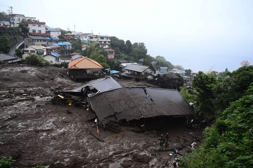 Members of Japan's Self-Defense Forces search for missing people in the mud after a landslide following days of heavy rain in Atami in Shizuoka Prefecture.