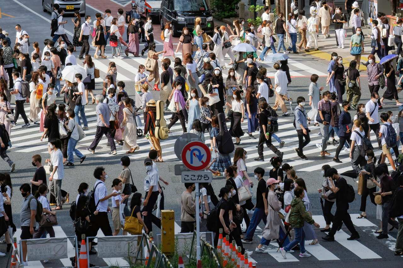 Pedestrians wear face masks at the Shibuya Crossing in Tokyo. 