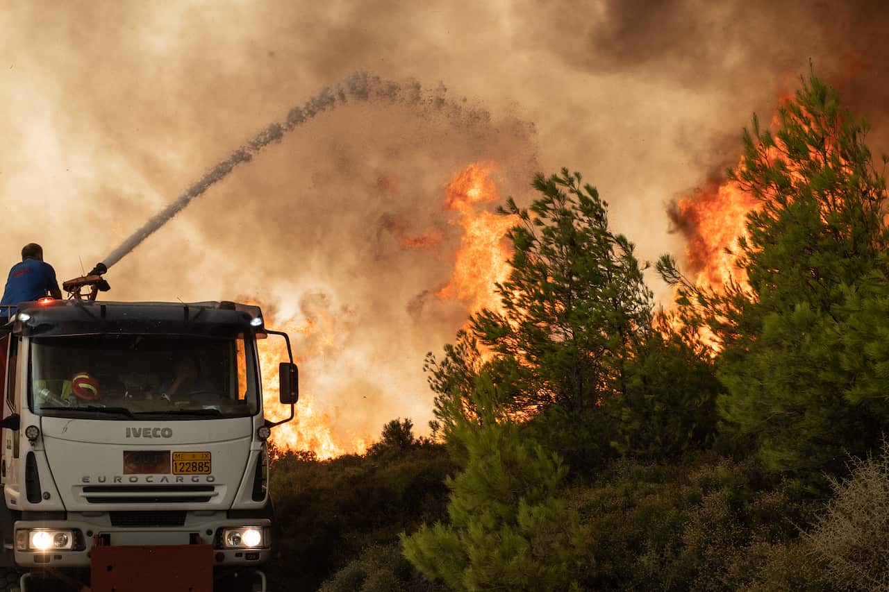A firefighter battles the flames in Athens, Greece, on 6 August, 2021.