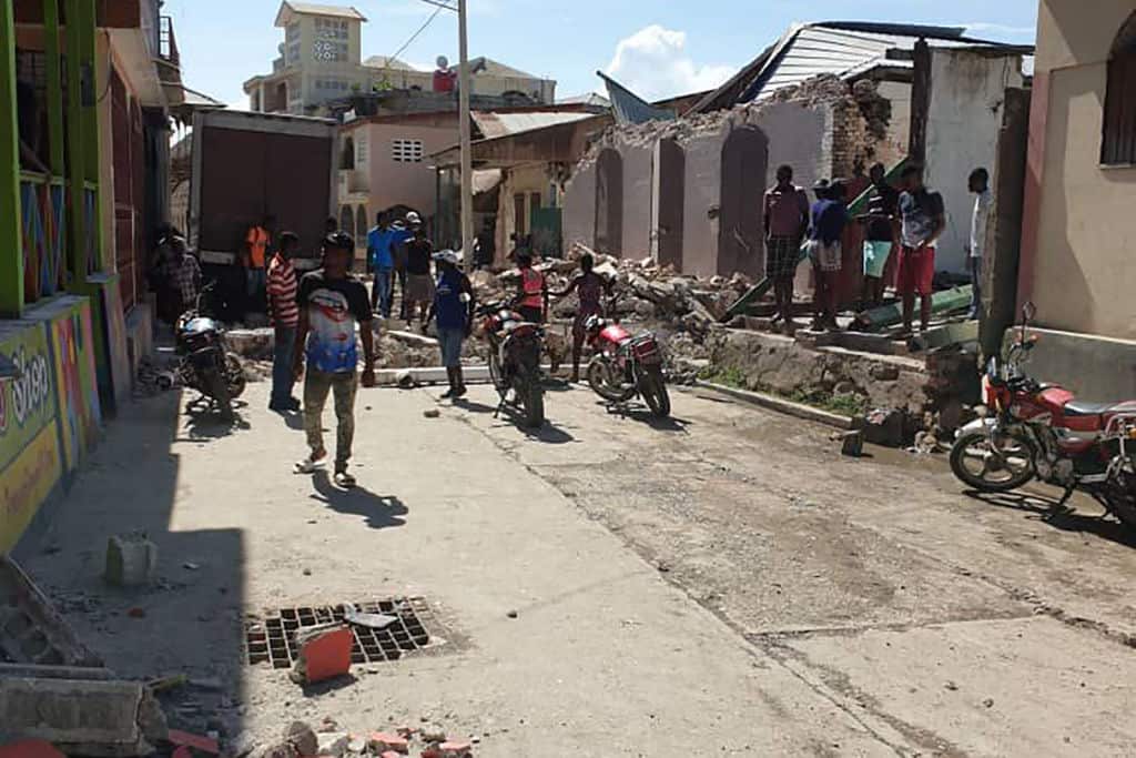 People watch destroyed houses after an earthquake struck in south-west Haiti.