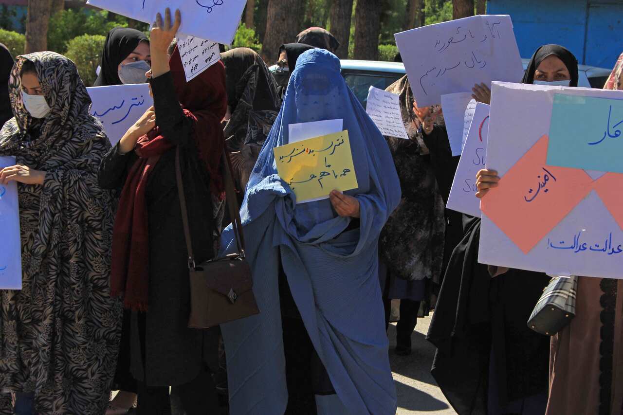 Afghan women hold placards as they take part in a protest in Herat