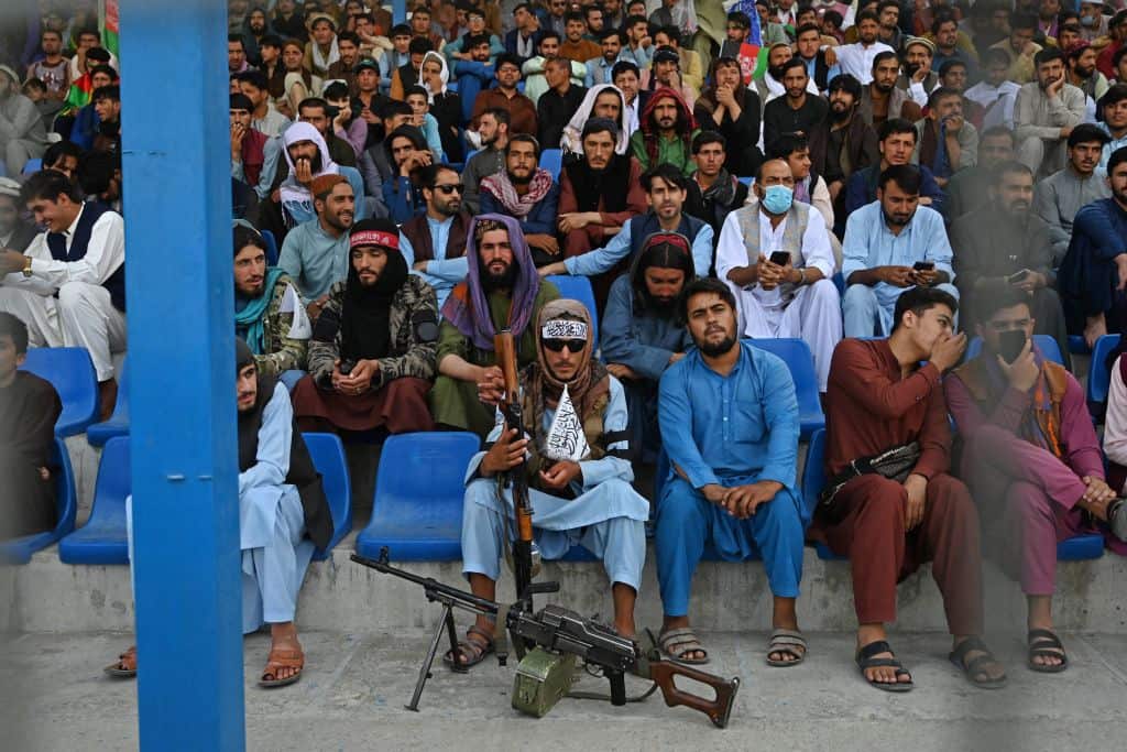 A Taliban fighter (C) keeps vigil as spectators watch the Twenty20 cricket trial match being played between two Afghan teams in Kabul in September.